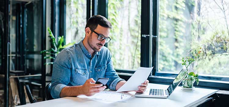 an accounting professional works at his computer and decides if he is going to get a master's degree