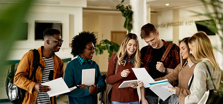 students smile as they look at a letter held by one student