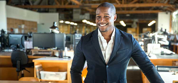 tech business administrator stands in office with computers