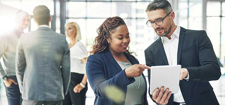 businessman shows colleage data on tablet during break in meeting