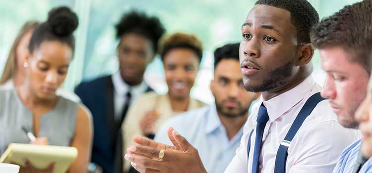 man in focus speaking to group of students out of focus