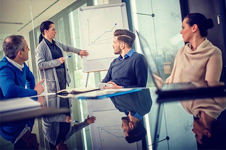 career in corporate finance professionals viewing profit charts in conference room