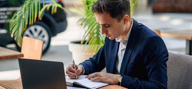 auto insurance agent works at desk on numbers for auto loan