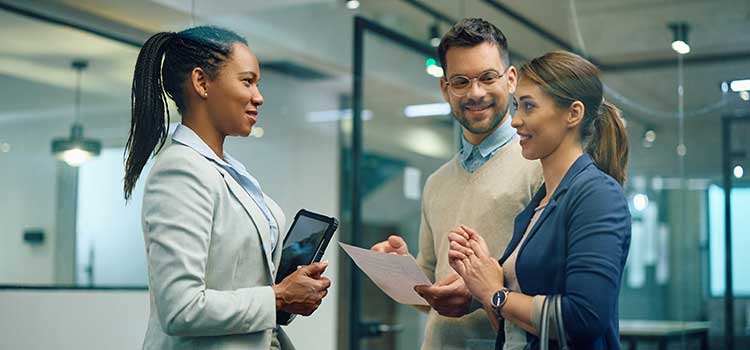 banker speaks with clients in hallway