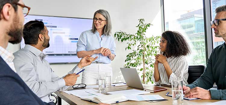 marketing manager discusses projects during meeting with senior team