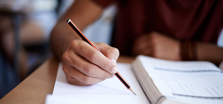 close-up of hand holding pencil taking a test