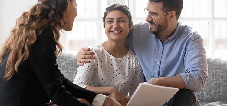 sports agent signing papers with young female athlete and family member