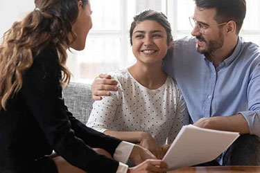 sports agent signing papers with young female athlete and family member