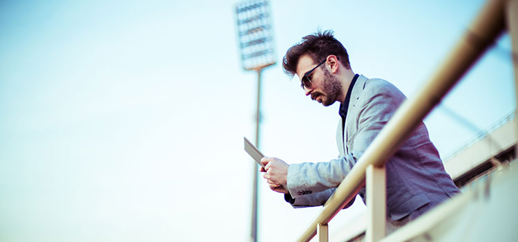 man looking at phone at outdoor stadium