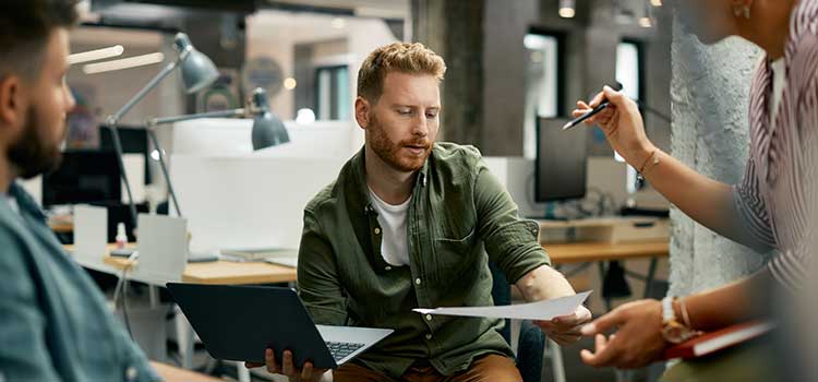 casual business administrators discuss project in busy office