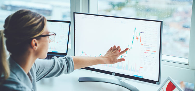 A woman examines a chart on her laptop.om