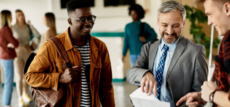 professor talking to two students in the hallway